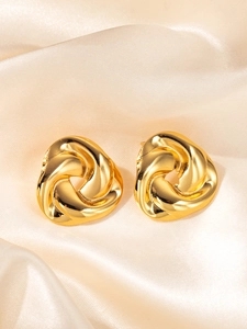 Détail de boucles d'oreilles spirales à trois pétales en acier doré sur soie
