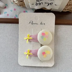 Detail of two-piece pink ribbon bow hair clips with sweet heart print round buttons