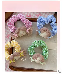 Détail de chouchous en tissu à carreaux avec poupées en rose, bleu, jaune et vert