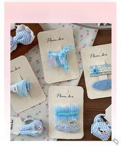 Détail de barrettes à nœuds bleus et chouchous à fleurs sur fond en bois rustique