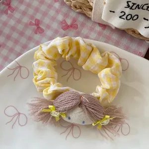 Gros plan détaillé du chouchou à carreaux jaunes avec figurine mignonne sur platine