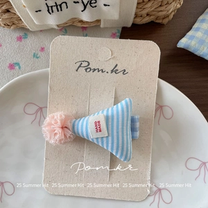 Détail de la pince à cheveux chapeau de fête à rayures bleues et pompon rose