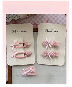 Détail de pinces à cheveux à nœud rose à carreaux avec perles sur carte