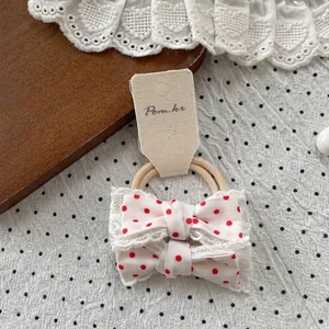 Detail von roten Polka-Dot-Haarschleifen mit weißer Spitze auf einer Displaykarte