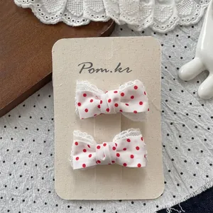 Detail süßer roter Polka-Dot-Haarspangen mit feinen weißen Spitzenrändern für Mädchen