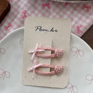 Gros plan de barrettes à cheveux nœud rose avec perles sur carte de support