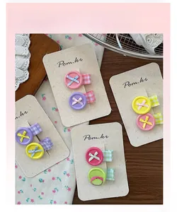 Detailed view of button bow hair clips on cardboard in various plaid patterns