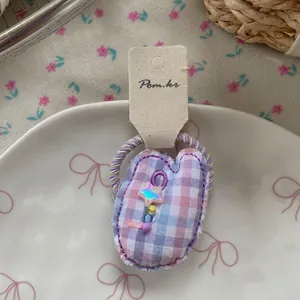 Détail d'un chouchou à carreaux vichy rose avec étoiles irisées et perles colorées