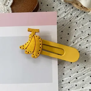 Detailed close-up of a yellow banana hair clip with precision stitching and metal clamp