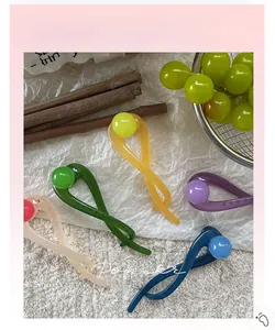 Macro shot of minimalist resin twist hair clips with round beads in five pastel colors
