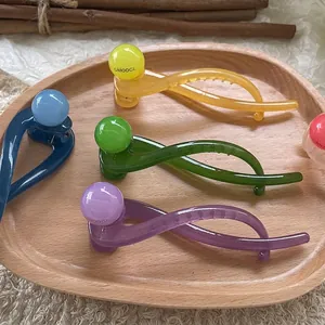 Pastel jelly twisted hair clips with round beads for women in a wooden display tray