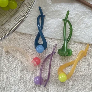 Colorful banana hair clips in summer shades on a clean aesthetic background