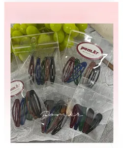Detailed view of Morandi color teardrop hair clips in transparent pom.kr packaging