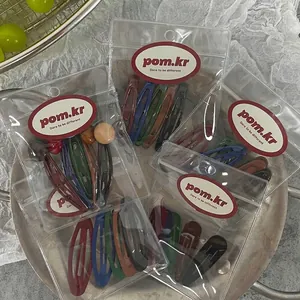 Matte finish water drop hair clips in deep colors on a decorative round tray