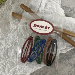 Detail view of 5-color oval metal snap hair clips in transparent zipper bag packaging