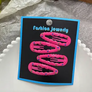 Close-up of four pink polka dot hair clips set on a stylish fashion jewelry display card
