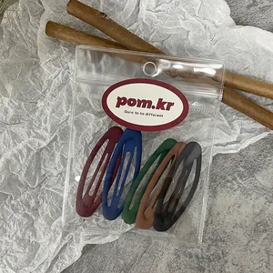 Detailed view of five matte snap hair clips in vintage colors on a card in a clear bag