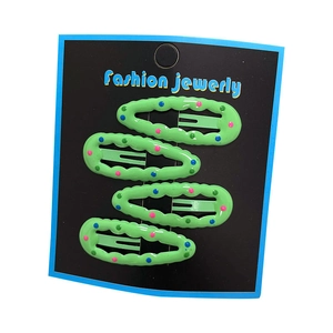 Set of 4 green polka dot BB hair clips with wavy edges for girls on a display card