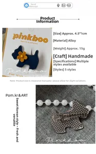 Detaillierte Nahaufnahme einer blauen Stoff-Hundebrosche mit gelbem Blumenakzent und Legierung