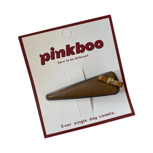 Barrette à cheveux en cuir litchi marron avec nœud sur carte de présentation rose