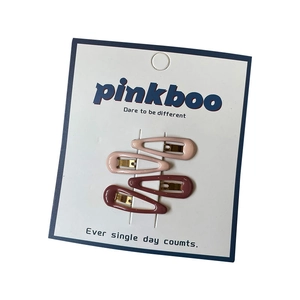 Pink and reddish-brown heart-shaped hair clips on a professional display card set