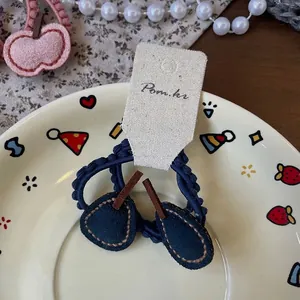 Détail de chouchous cerises bleus tricotés sur carte de présentation enfant