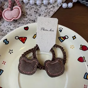 Gros plan sur les élastiques à cheveux ours en daim marron sur une assiette déco