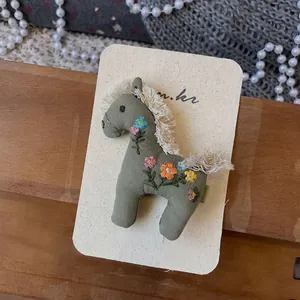 Détail de la pince à cheveux poney faite main vert olive avec broderie florale