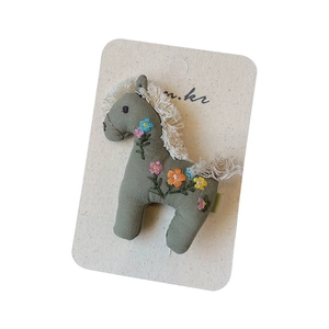 Broche poney en tissu faite main avec broderies florales et détails de franges en coton