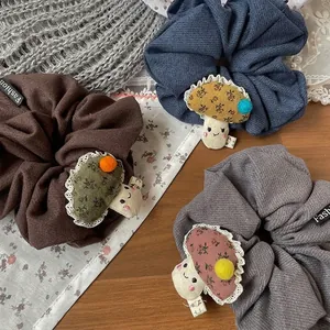 Trois chouchous d'automne avec champignons en marron, bleu et gris sur fond de bois