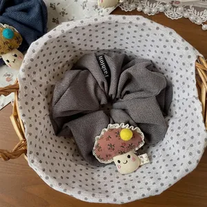 Gros plan d'un chouchou gris avec pendentif champignon fait main et motifs floraux