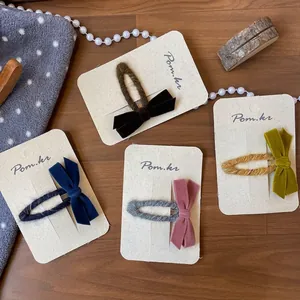 Handgefertigtes Samtschleifen-Haarspangen-Set in vier Vintage-Farben auf Holz