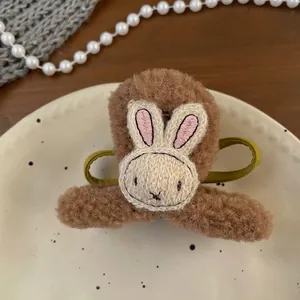 Detailed view of plush lamb hair hair claw with cute embroidered beige rabbit pattern