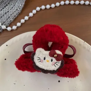 Detail of red plush hair claw clip with embroidered cartoon cat on a ceramic plate