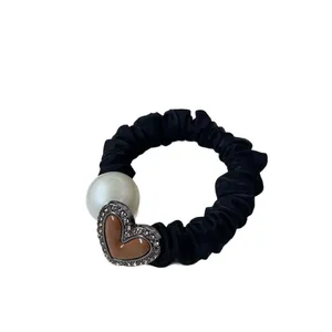 Elastico per capelli nero con perla bianca e ciondolo a cuore marrone con strass luccicanti