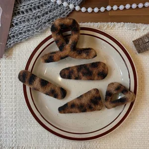 Plush leopard print hair clip set with claw and snap pins on a vintage plate