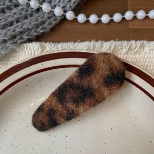 Macro shot of plush leopard print hair clip with soft autumn texture on ceramic plate