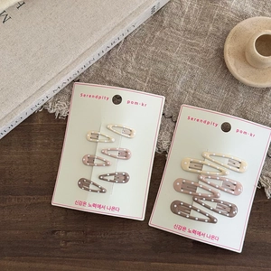 Detailed view of Morandi color polka dot hair clips set on paper display cards