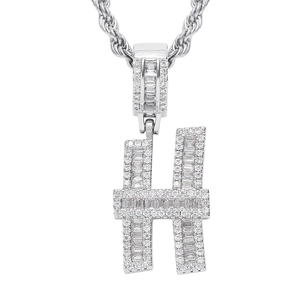 Macro detail of silver-tone letter H pendant with iced out baguette and round zircons