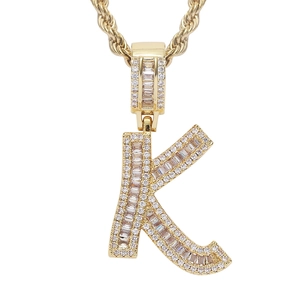 Close-up of golden letter K pendant with pave-set baguette zircons and rope chain