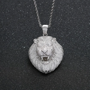 Vue macro d'un pendentif tête de lion hip hop argenté avec zircons micro-paves et chaîne