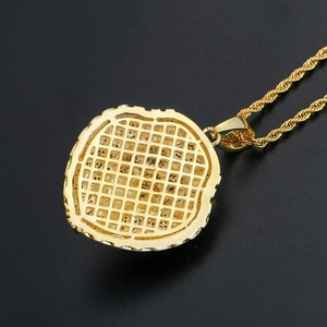 Détail macro du pendentif tête de lion avec dos alvéolé et chaîne torsadée dorée