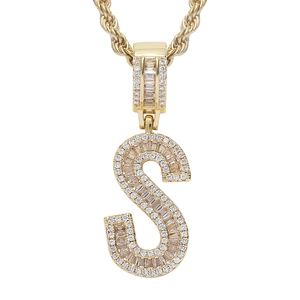 Macro detail of iced-out letter S pendant with baguette-cut zircons and rope chain