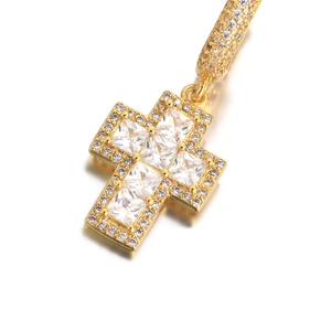 Vue macro d'un pendentif croix hip hop doré avec zircons carrés et ronds