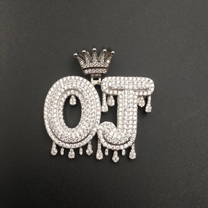 Close-up of silver OJ hip hop pendant with crown and dripping effect in zircon
