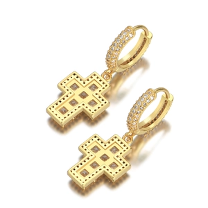 Détail de boucles d'oreilles croix dorées serties de zircons cubiques de style hip-hop