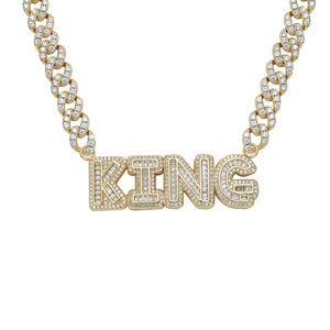 Macro detail of gold plated Cuban chain and iced out KING pendant with cubic zirconia