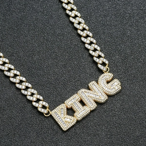 Close-up of iced out KING letter pendant on 9mm Cuban link chain for hip hop style