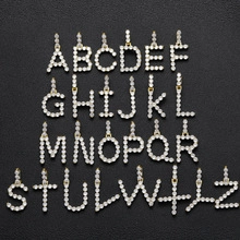 Flat lay of 26 bubble letter pendants in gold with sparkling white cubic zirconia stones