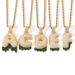 Detail of hip hop bubble letter pendants with green lava effect and pavé set zircons